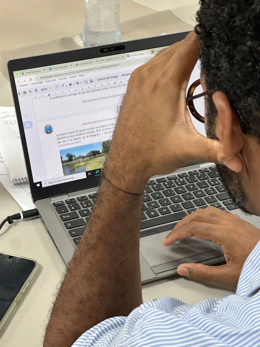 Un chargé de projet travaille sur le compte rendu d'une visite de terrain